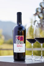 Image of a bottle of 2022 HALL Coeur Cabernet Sauvignon next to two glasses of red wine.